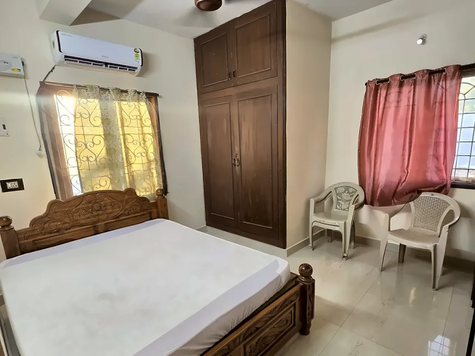 Furnished bedroom with air conditioner and wardrobe in Unit 3B at Raaj Illam